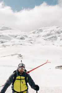 Athlete on skis on pico aunamendi in snowy pyrenees mountains under cloudy sky in navarre spain