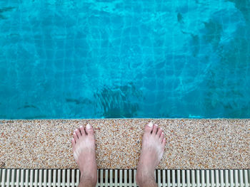 Low section of man standing at poolside