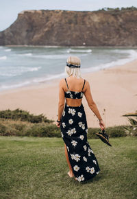 Rear view of woman standing at beach