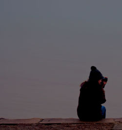 Silhouette woman with arms raised against sky at night