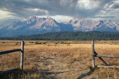 Scenic view of field and mountains against sky