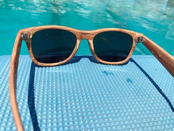 Close-up of sunglasses on table against swimming pool