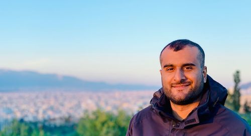 Portrait of smiling man against sky