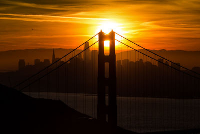 Silhouette of suspension bridge during sunset