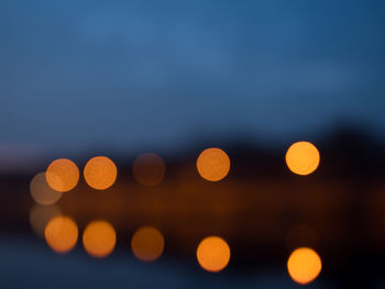 Defocused lights against sky at night