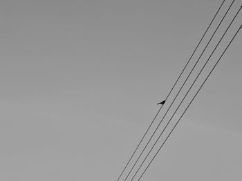 Low angle view of power lines against clear sky