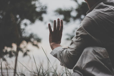 Midsection of man gesturing on field