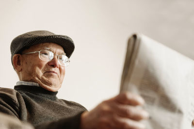 Low angle view of senior man holding newspaper