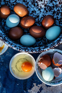 High angle view of brown and blue eggs on table during preparation 