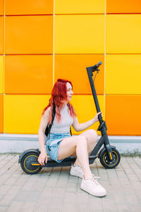 Full length of young woman exercising on street