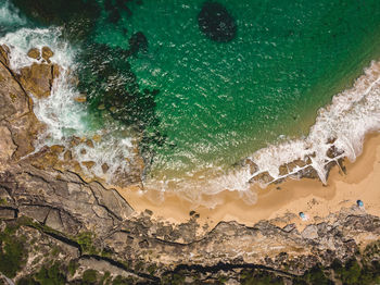 High angle view of sea waves hitting rock formations