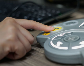 Cropped image of person pressing medical equipment button on table