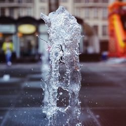 Close-up of water splashing on fountain in city