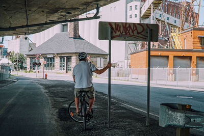 Rear view of man riding bicycle on street