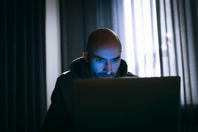 Man working on laptop in dark office