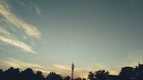 Low angle view of silhouette bird flying against sky