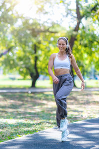 Full length of woman exercising on road
