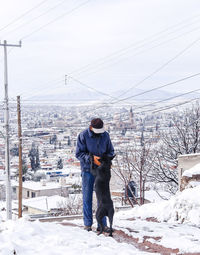 Full length of man standing on snow covered landscape