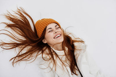 Portrait of young woman wearing hijab against white background