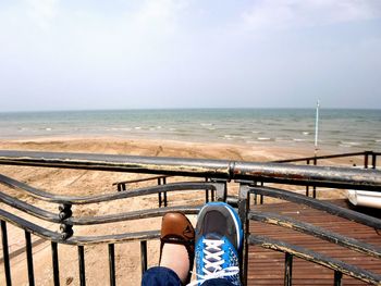 Low section of man standing on pier