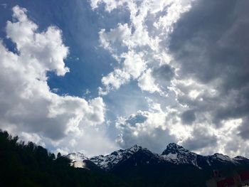 Scenic view of snow covered mountains against cloudy sky