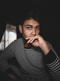 Portrait of young man sitting at home