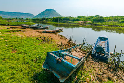 Abandoned boats moored on lake against sky
