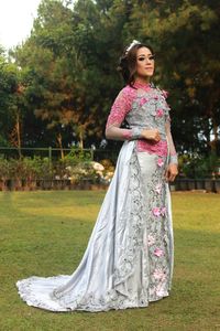 Full length of woman standing by tree