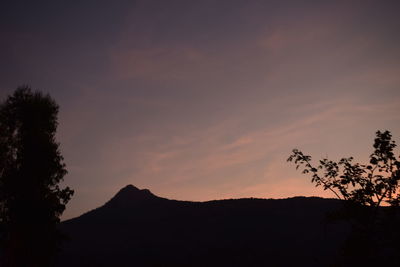 Low angle view of silhouette mountains against sky at sunset