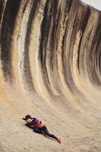 Young woman sliding on rock formation