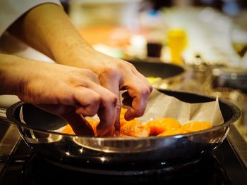 Close-up of cropped hands preparing food in kitchen