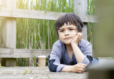 Portrait of boy lying on wood