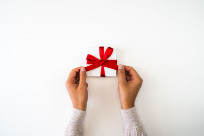 Midsection of woman holding paper against white background