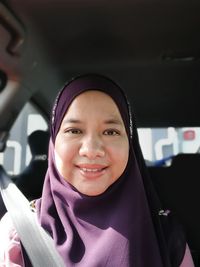 Portrait of smiling young woman in car