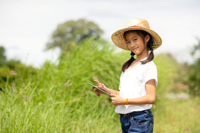 Full length of woman wearing hat standing on field