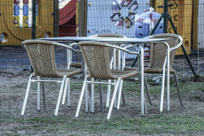 Empty chairs and tables at sidewalk cafe against buildings