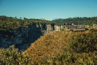 People at belvedere on the edge of cliff at the itaimbezinho canyon near cambara do sul. brazil.