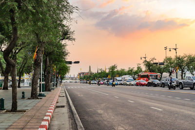 View of city street against sky during sunset