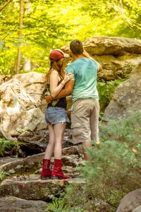 Rear view of couple walking in forest