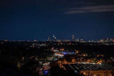 High angle view of illuminated cityscape against sky at night