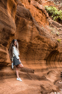 Full length of young woman standing on rock