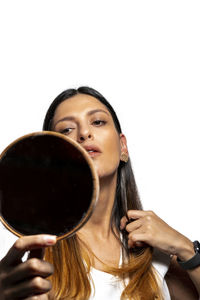 Portrait of woman holding camera over white background