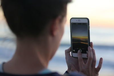 Cropped image of woman photographing through camera