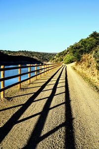 View of empty road against clear blue sky