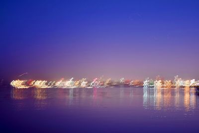 Scenic view of lake against clear blue sky at night