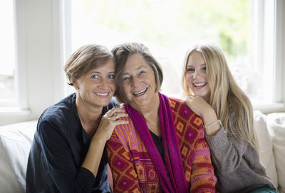 Portrait of happy three generation females in living room