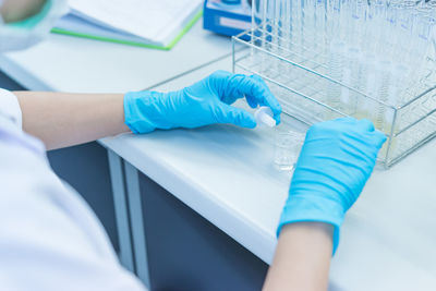 Midsection of scientist holding laboratory equipment
