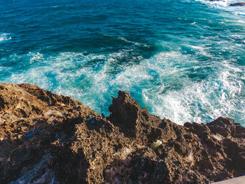 High angle view of rock formation by sea during sunny day