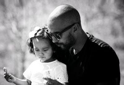 Close-up of father with daughter against sky