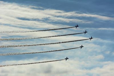 Low angle view of airplane against cloudy sky